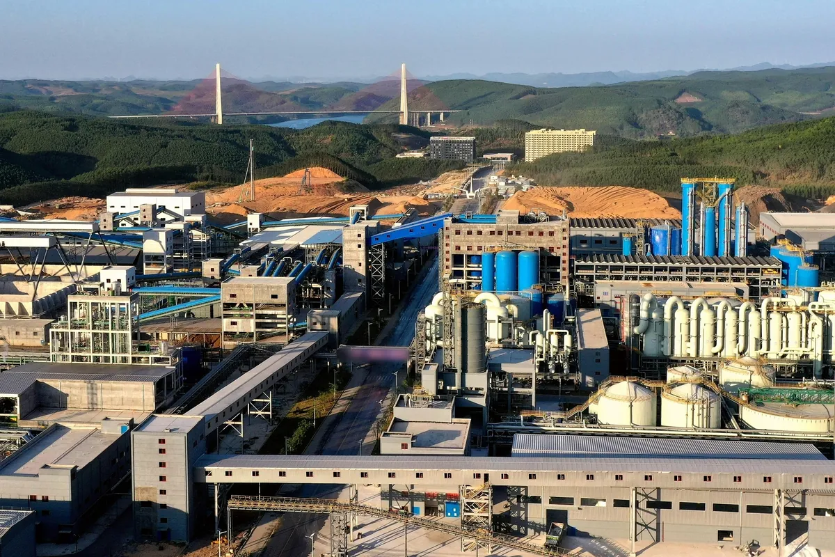 An industrial plant and a bridge among green hills